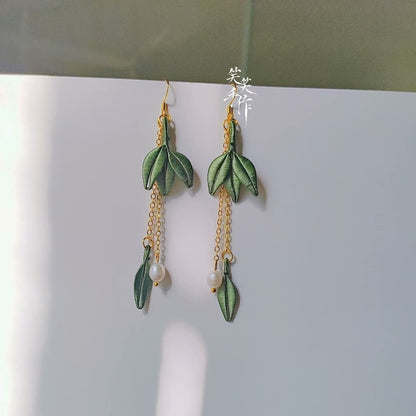 Close-up of a pair of artisan-made Chanhua embroidered leaf earrings featuring elegant freshwater pearls and sterling silver hooks.