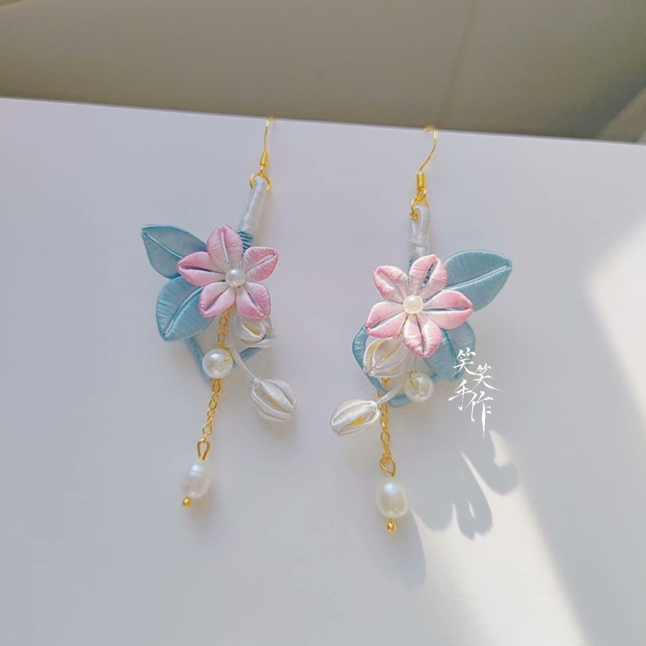 Handcrafted Chanhua flower dangle earrings with natural freshwater pearls and 925 silver hooks, front view.