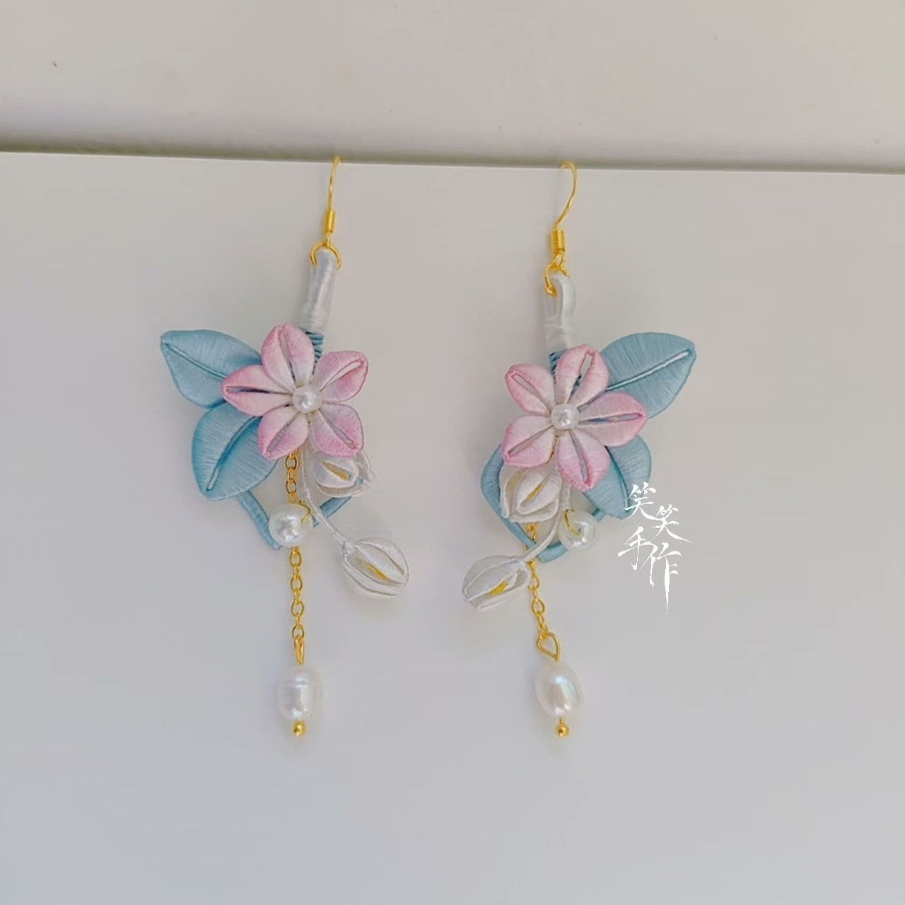 Elegant pink Chanhua flower and blue leaf earrings with dangling pearls, showcasing artisan craftsmanship.