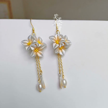 Handcrafted Chanhua floral dangle earrings in sky blue with 925 silver hooks and natural freshwater pearls, side view.