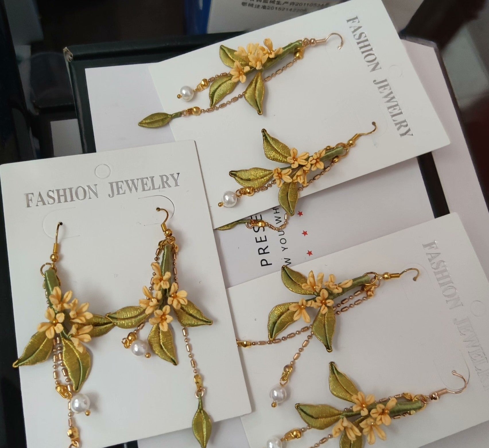 A collection of handmade Chanhua flower earrings displayed on white "Fashion Jewelry" cards.