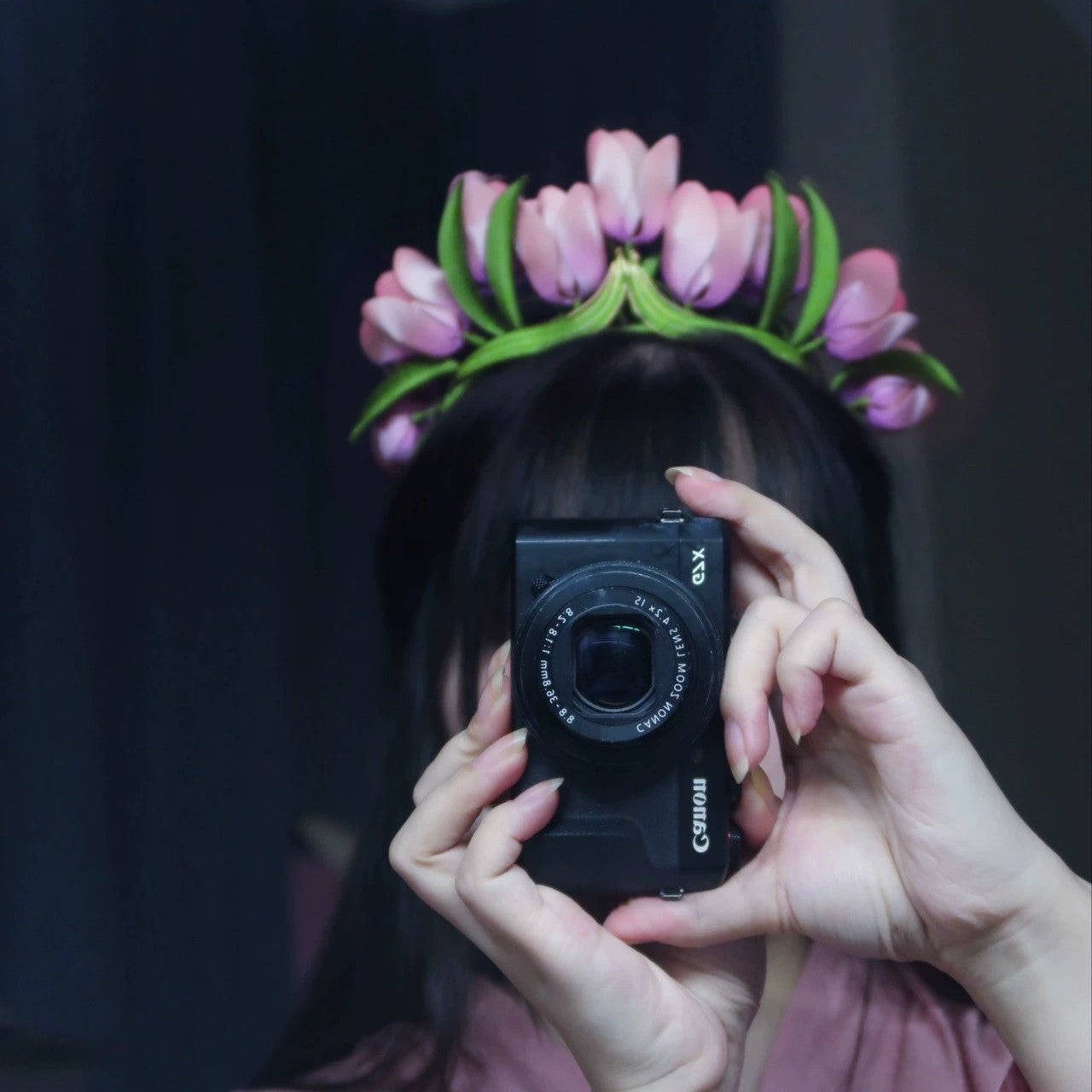 Close-up of a person wearing a handcrafted velvet tulip flower crown, holding a camera, showing the elegant design.