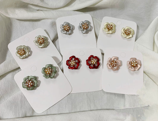 Collection of various colored handcrafted Chanhua floral stud earrings on white display cards.