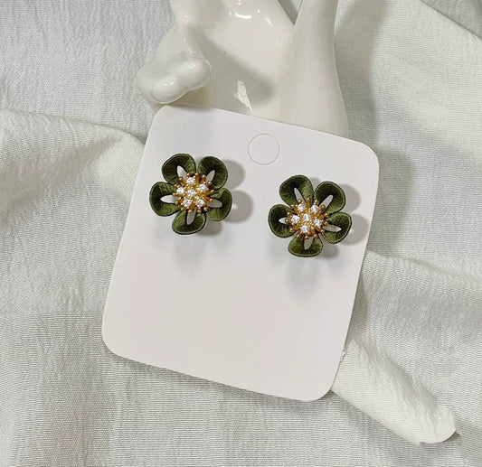 Close-up of handmade Chanhua flower earrings with detailed green petals and sparkling crystal centers on a white card.