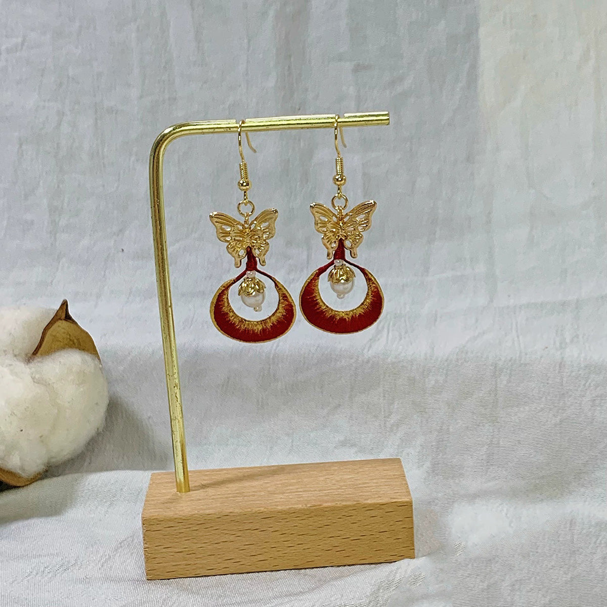 The Chanhua earrings displayed on a stand, highlighting the 925 sterling silver ear hooks.