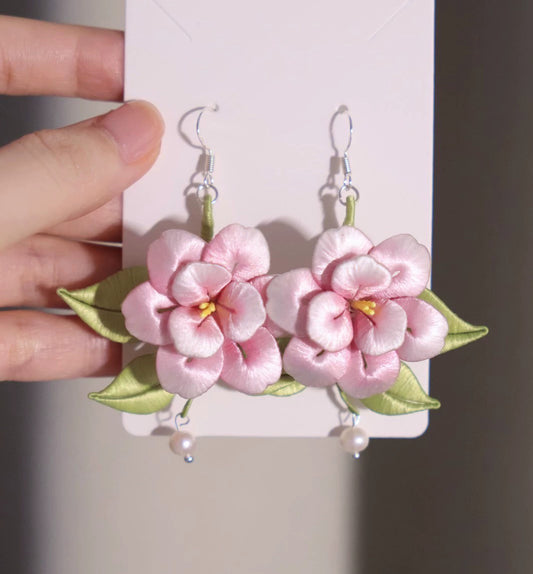 Close-up of the delicate pink Chanhua earrings, showing the intricate handmade details and lustrous pearl.