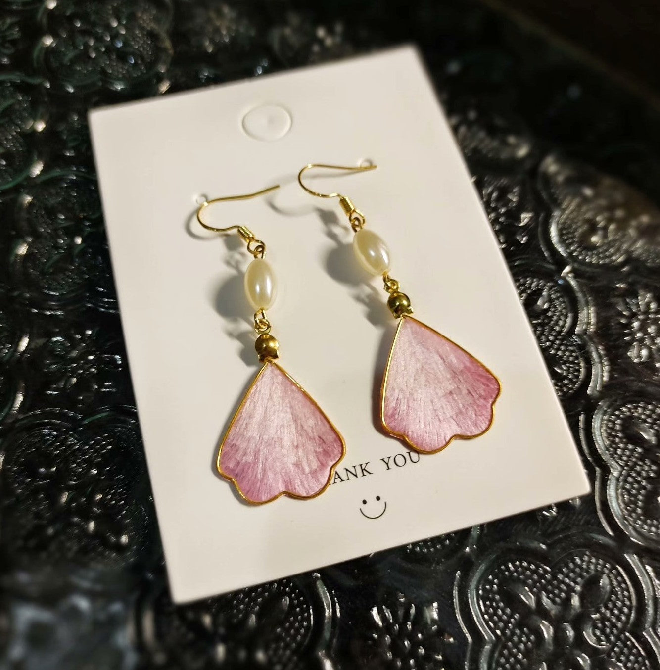 Handmade silk Ronghua earrings in a soft pink petal shape with a pearl, dangling from a 925 silver hook.