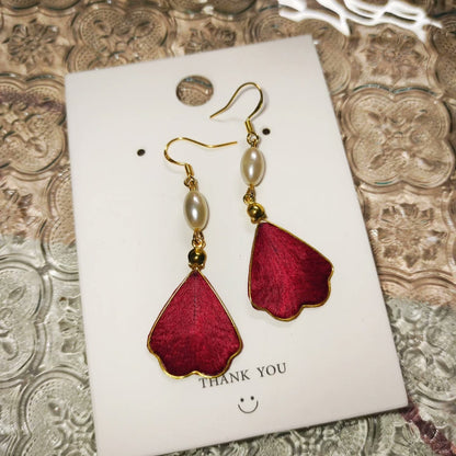 A pair of deep red handmade silk Ronghua petal dangle earrings with a delicate pearl accent.