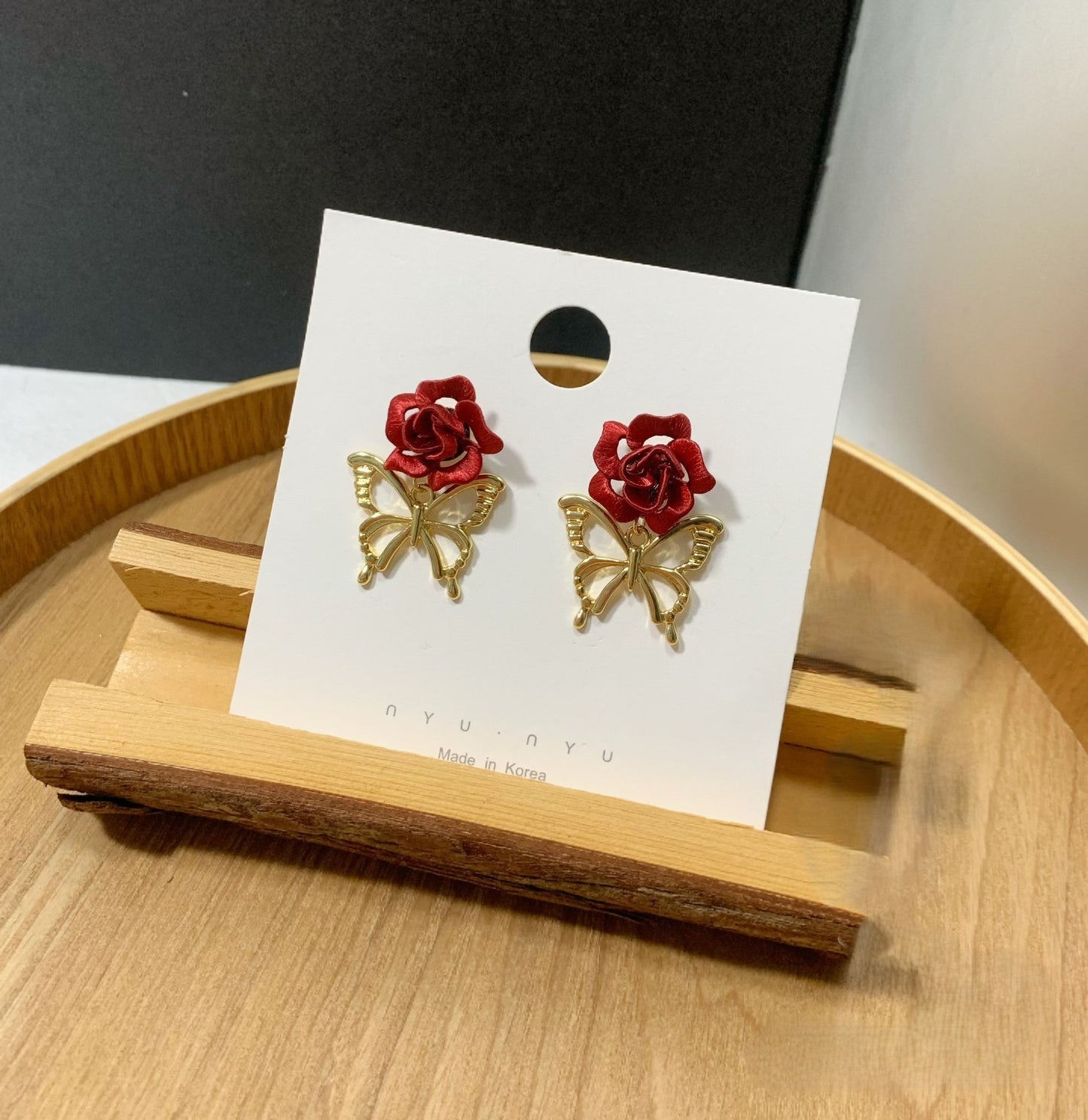 Close-up of handmade Chanhua red rose butterfly earrings on display card, Korean style silk thread floral earrings