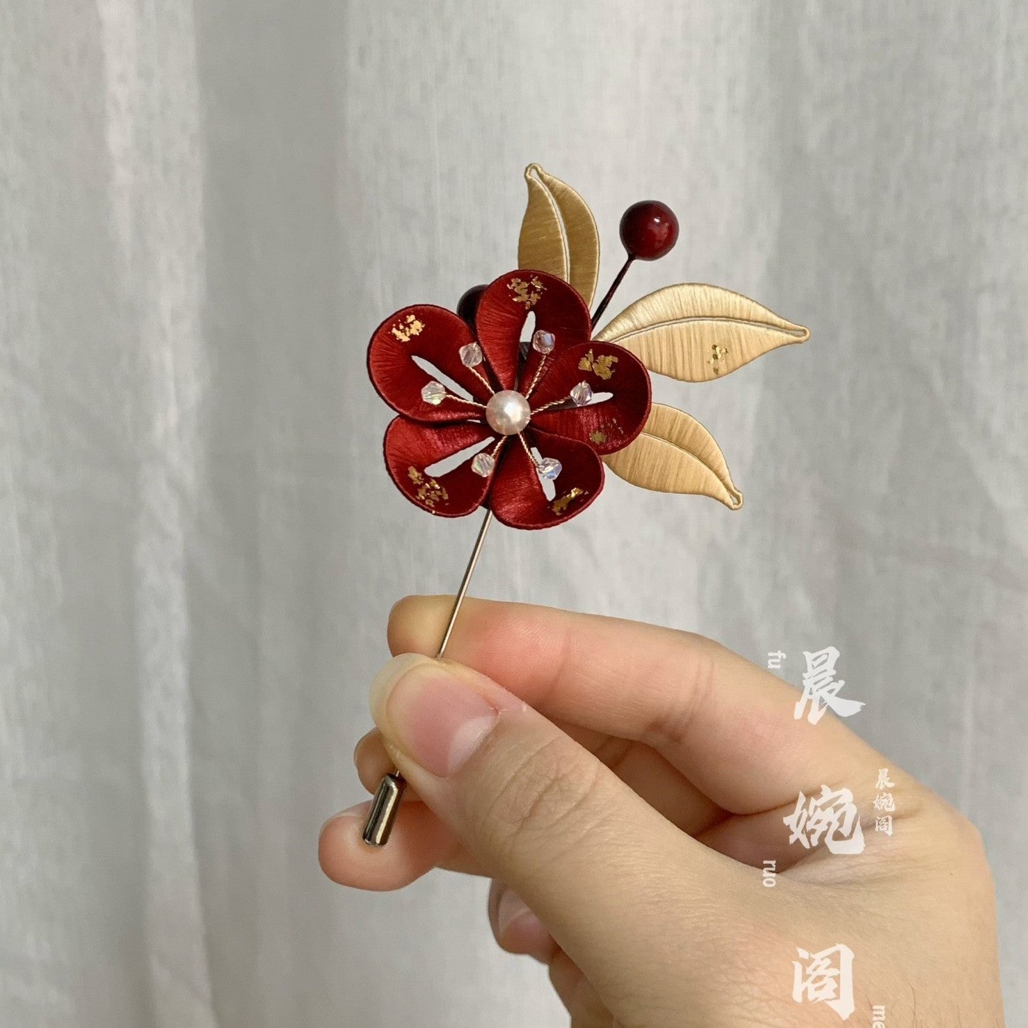 Handmade Chanhua plum blossom brooch in red thread petals with pearl center, gold leaves, crystals, and red berries, elegant flower lapel pin
