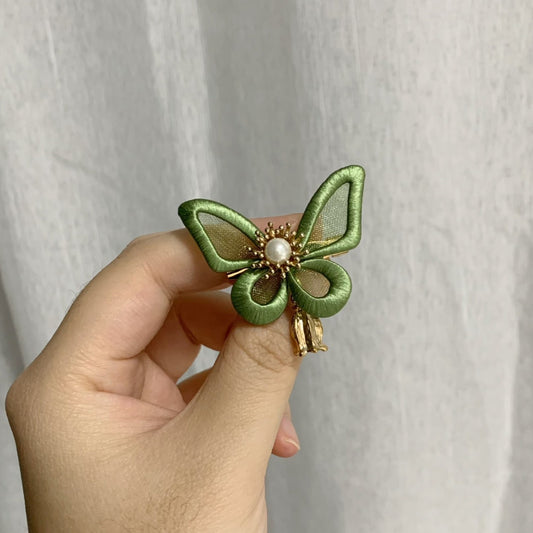Handmade Chanhua green butterfly brooch with thread wings, pearl center, gold beads, and small bell charm, elegant butterfly lapel pin