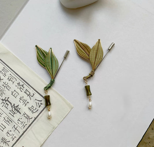 Handmade Chanhua leaf brooch in green thread leaves with gold veins, pearl drop, and small bead accents, elegant nature-inspired lapel pin