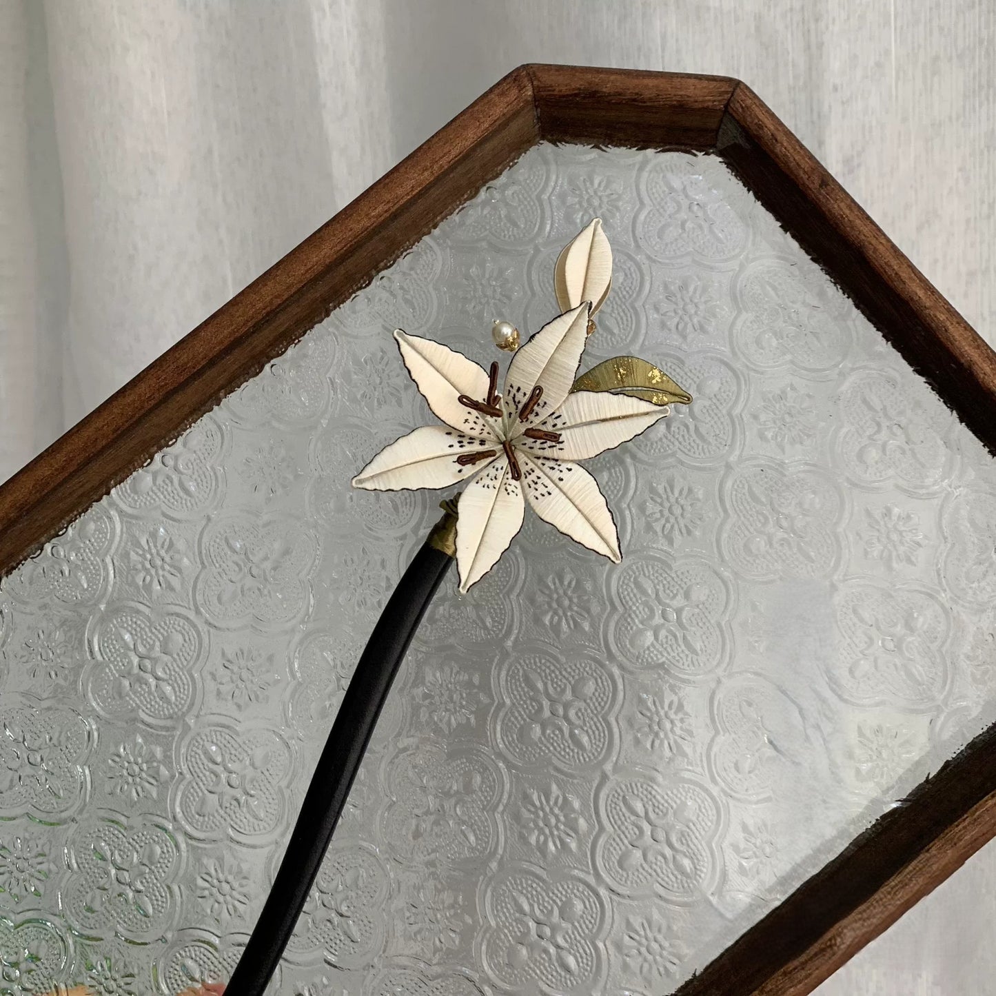 Handmade Chanhua lily hair stick with white thread flower petals, green-gold leaves, and pearl accents on black stick, elegant floral hair accessory