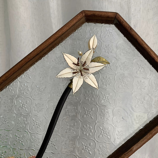 Handmade Chanhua lily hair stick with white thread flower petals, green-gold leaves, and pearl accents on black stick, elegant floral hair accessory