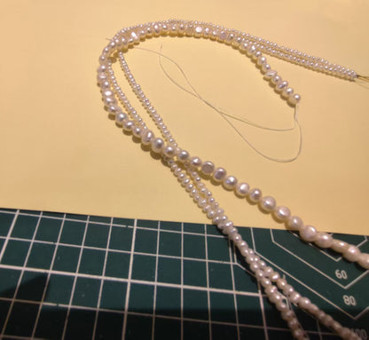 Close-up of multiple strands of irregular shaped freshwater pearls, ready for crafting.