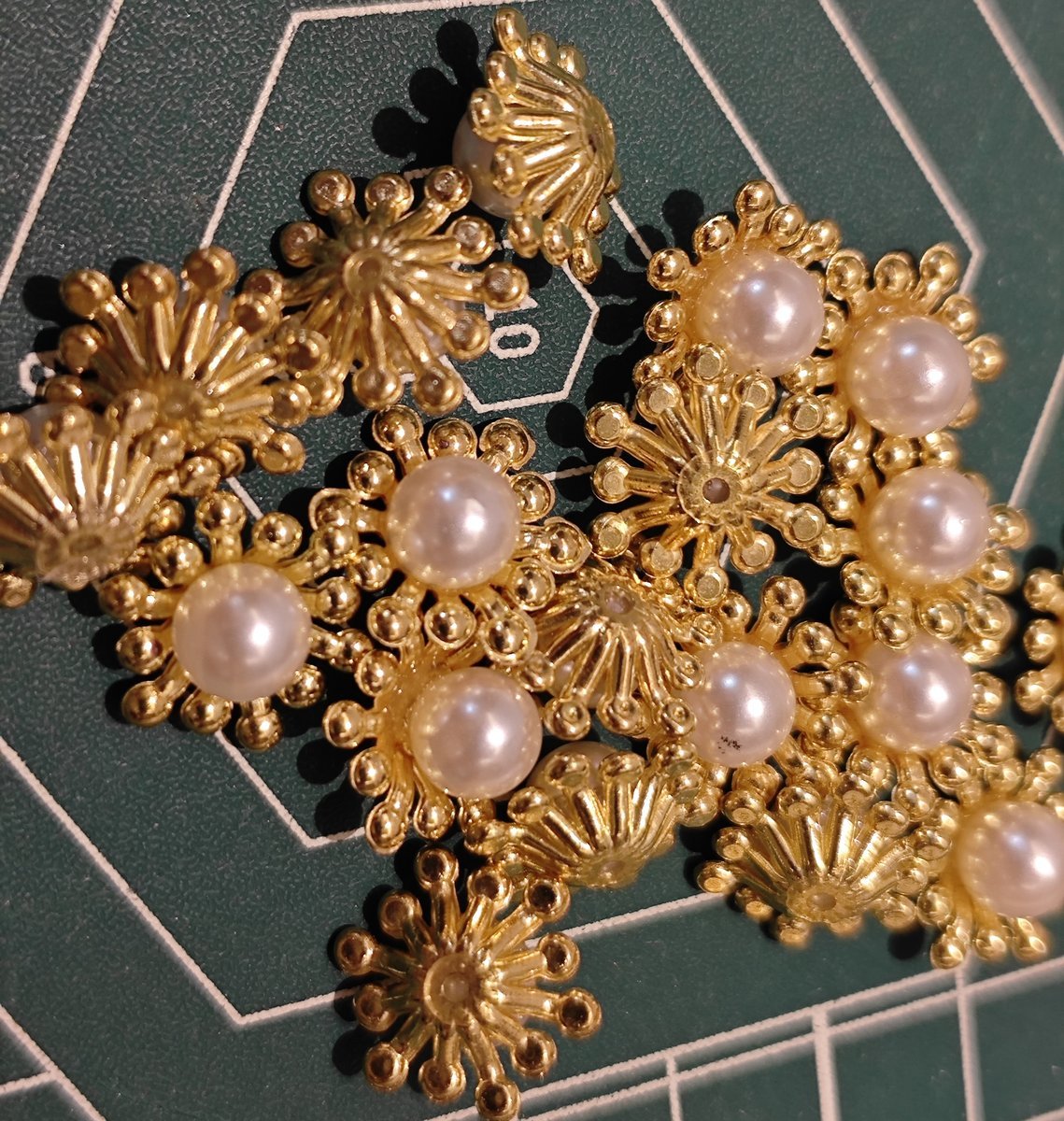 Close-up of gold metal flower centers with pearl for DIY jewelry making and Ronghua crafts.