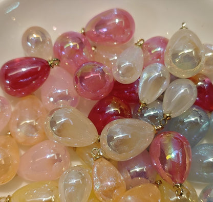 Assorted 10x14mm and 13x18mm glossy galaxy pendants in a white bowl, ready for DIY jewelry making and Ronghua crafts.