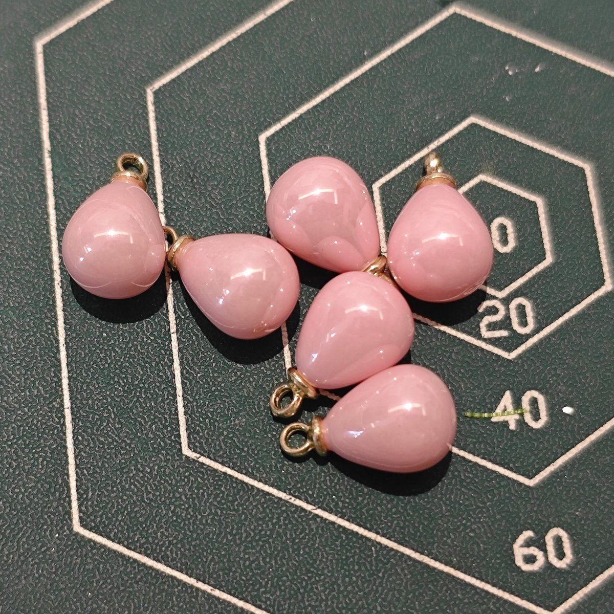Pile of pastel pink ABS plastic pendants for DIY earrings and Ronghua making supplies.