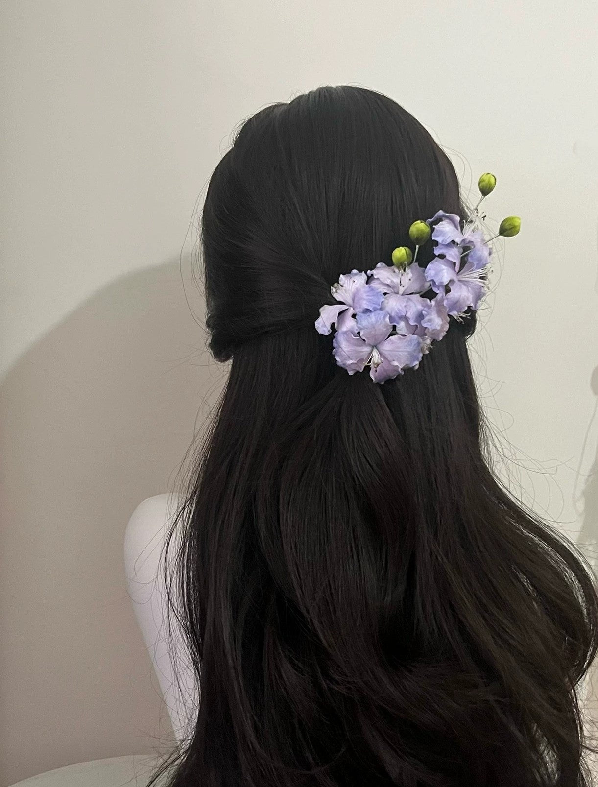 Image (Half-Up Hairstyle): Handcrafted lilac mulberry silk Ronghua flower hair clip securing a dark, flowing half-up hairstyle, ideal for a subtle formal look.