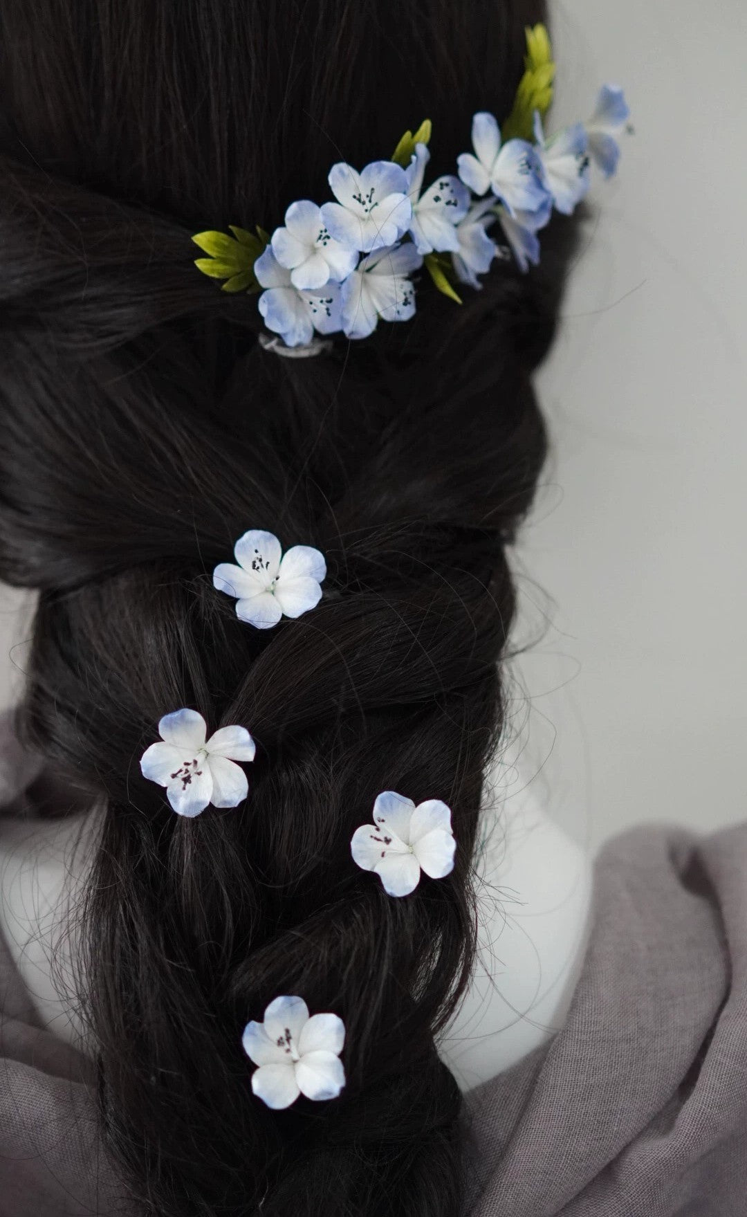 Full view of a long braided hairstyle adorned with a set of blue mulberry silk Ronghua flower hair pins, suitable for weddings or banquets.