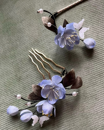 Close-up view of the handmade blue silk Ronghua hair accessory set, featuring a golden comb and a hair stick with pearl and flower accents.