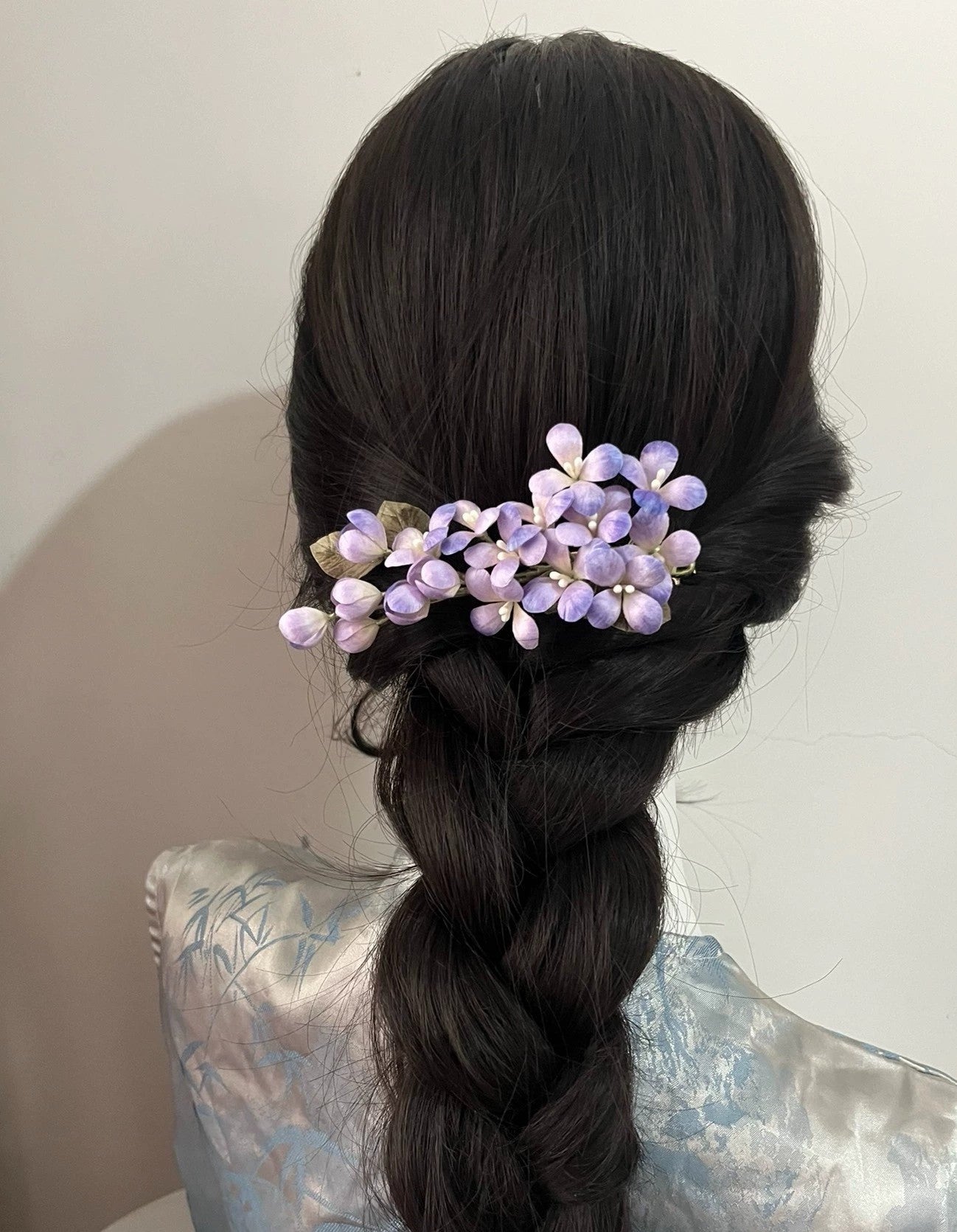 Elegant updo secured with a dark hair stick and adorned with a handmade lilac silk Ronghua flower pin, showcasing traditional styling.