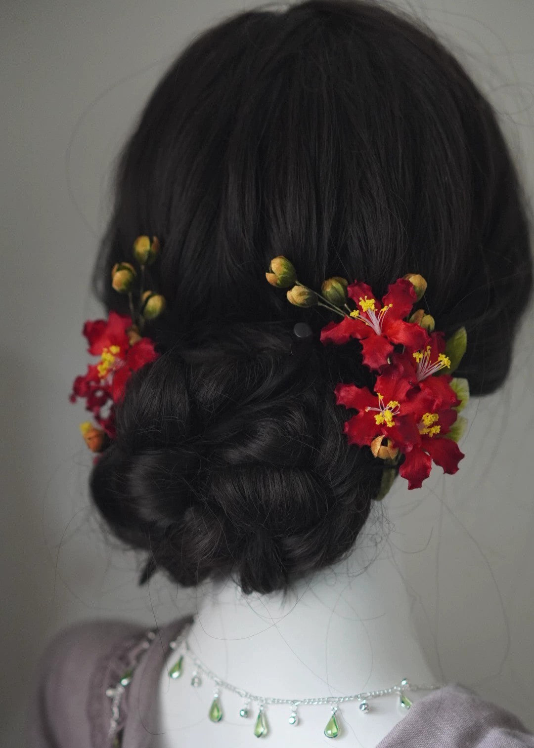 Elegant red Ziwei flower Ronghua silk hair accessories styled on a dark, low twisted hair bun/updo.