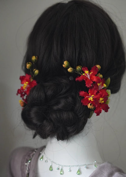 Elegant red Ziwei flower Ronghua silk hair accessories styled on a dark, low twisted hair bun/updo.