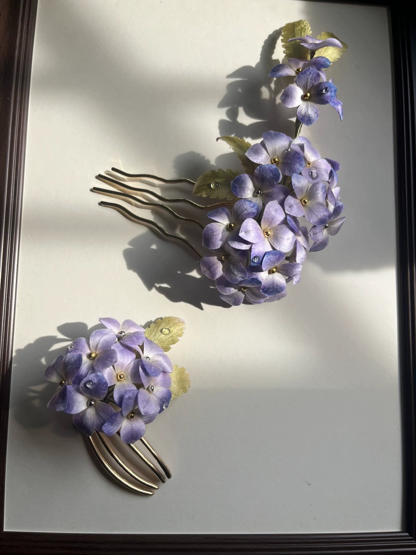 Two pieces of purple Hydrangea Ronghua silk hair accessories: a large comb and a small clip, displayed in sunlight.