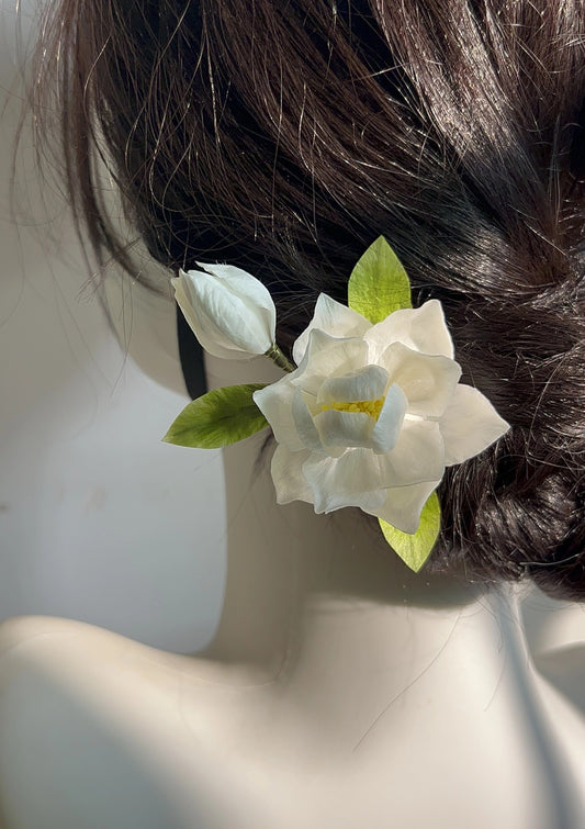 Close-up of a dark hair bun adorned with a handcrafted white mulberry silk Ronghua Gardenia flower pin and bud.