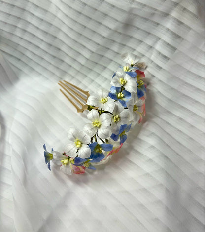 Close-up of the handcrafted mulberry silk Ronghua hair comb, detailing the individual white, blue, and pink flowers.