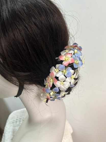 Close-up of a dark hair updo secured with a handcrafted blue and white mulberry silk Ronghua flower hair comb/pin cluster.