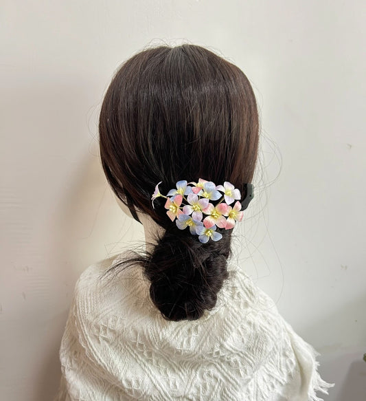 Handmade silk hydrangea Ronghua hair clip attached to a hair bun on a mannequin