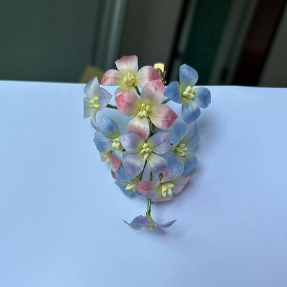 Close-up of handmade silk hydrangea Ronghua hair clip in pastel blue and pink tones