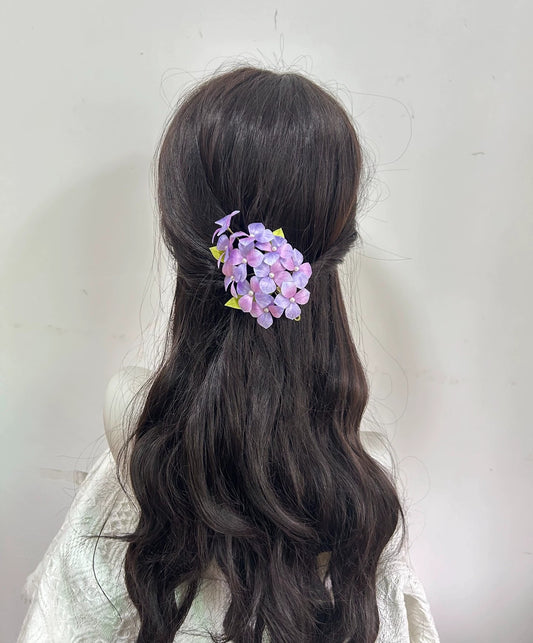 Back view of handmade purple flower Ronghua hair clip on mannequin ponytail