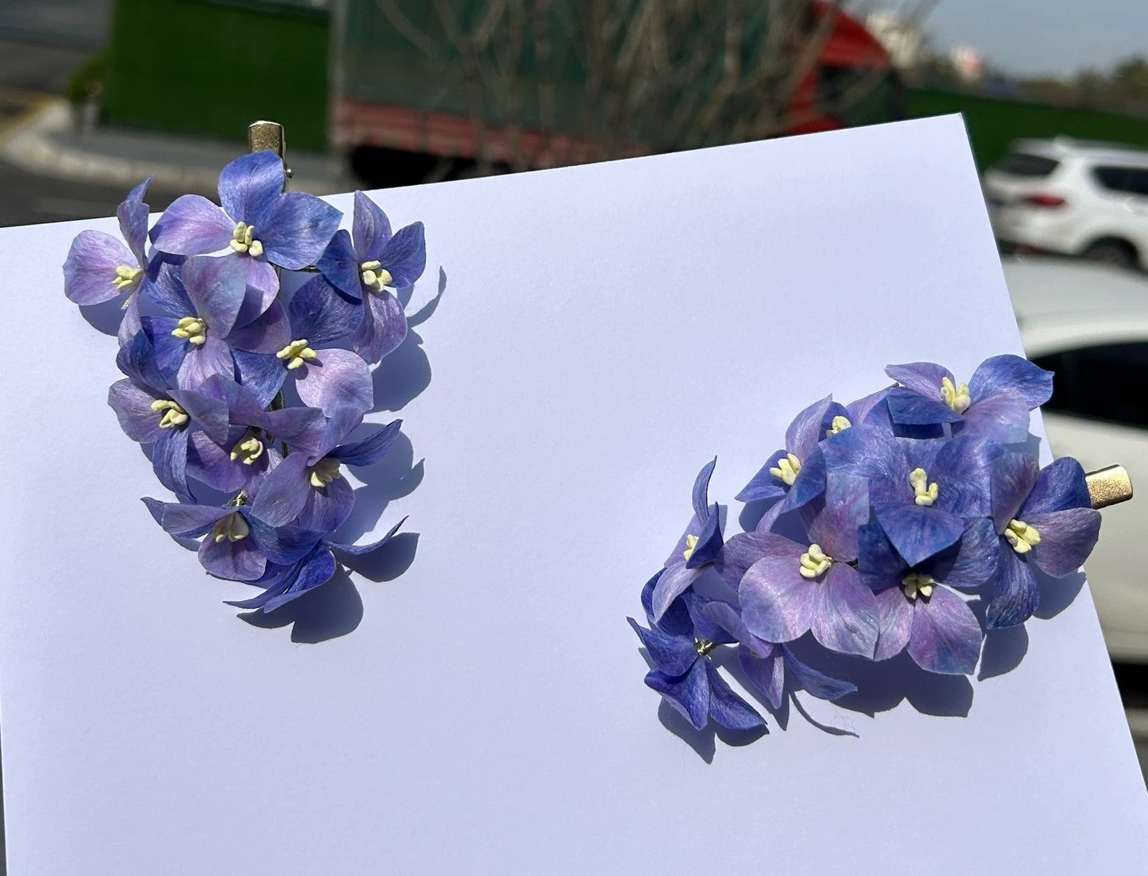 Two handmade purple hydrangea flower hair clips in natural silk thread on white background.