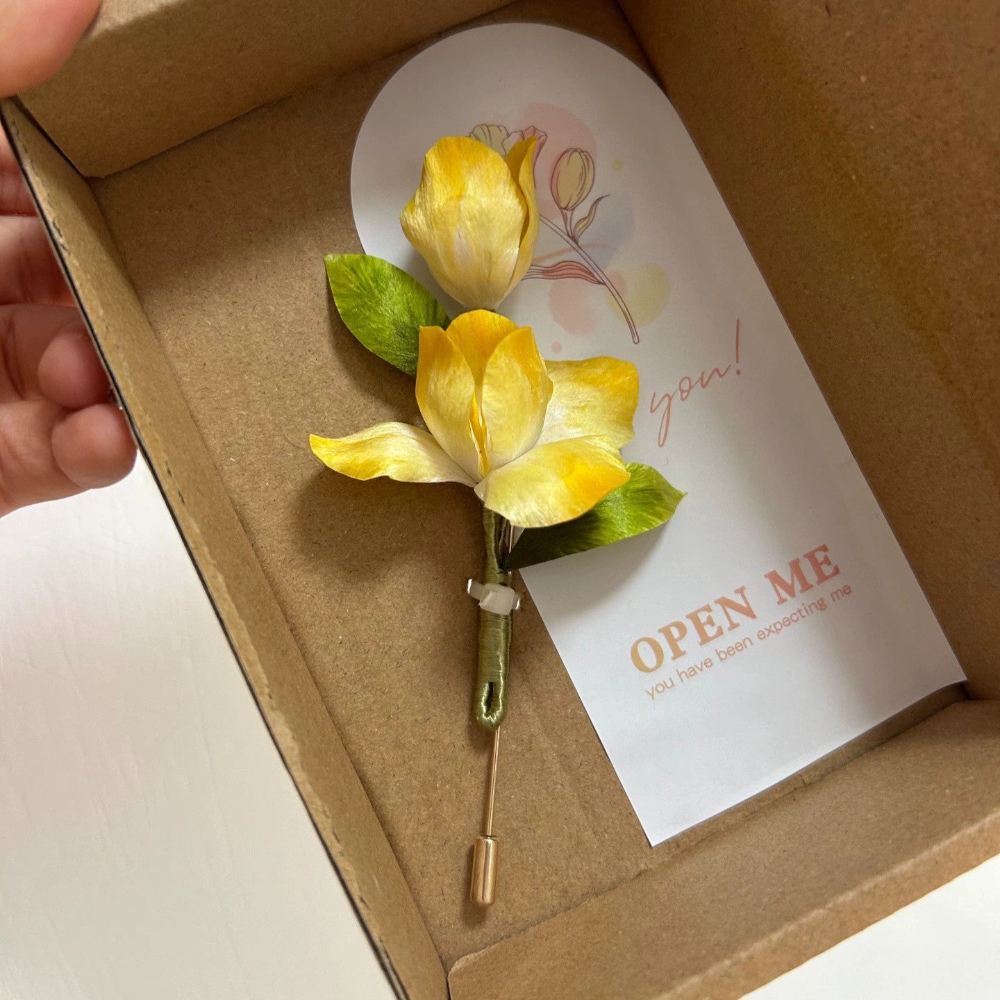 Handmade yellow iris flower brooch in natural silk thread inside open box with card.
