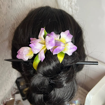 Purple silk Ronghua iris flower hair clip worn in elegant low chignon hairstyle on dark hair