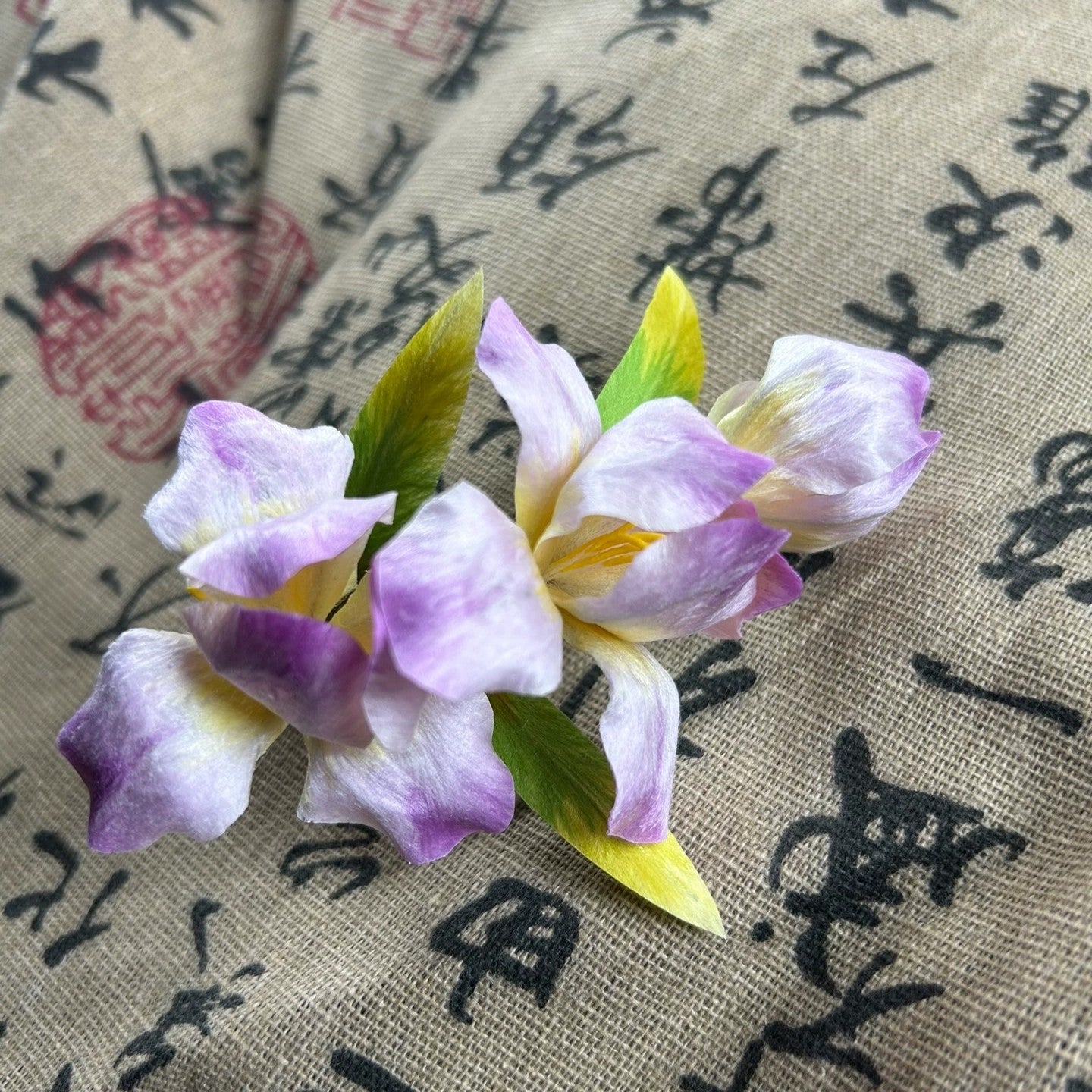 Side view of delicate handmade Chinese Ronghua iris floral hair accessory with alligator clip