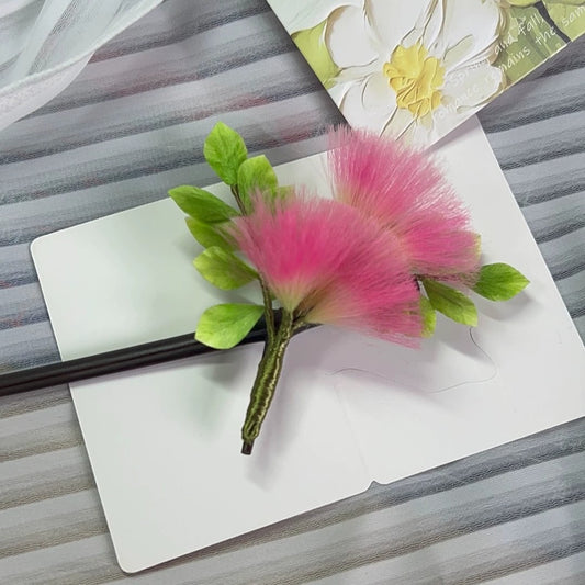 Delicate pink velvet Ronghua mimosa flower hairpin displayed on soft fabric with floral card background