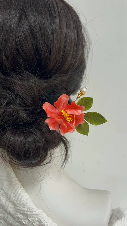 Handmade Ronghua pink camellia hair stick with pearl top worn in elegant updo on dark hair