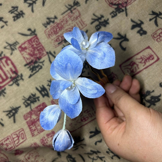 Detailed view of gradient blue velvet Ronghua hydrangea flowers made with natural mulberry silk thread on traditional Chinese calligraphy fabric