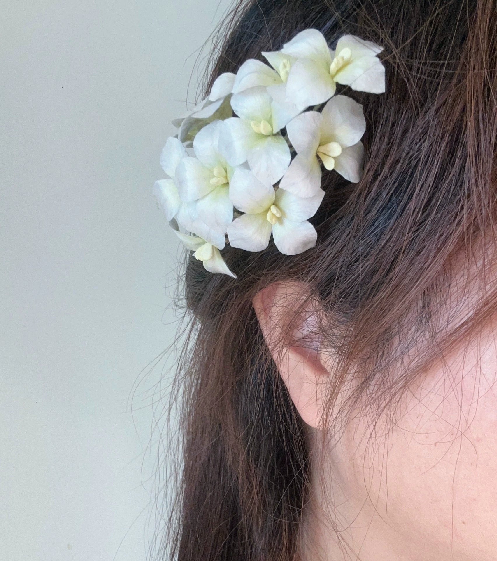 White velvet Ronghua hydrangea hair clip worn in elegant dark hair, soft natural side styling