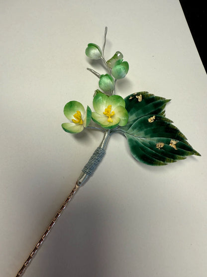 Close-up of mulberry silk Ronghua small flowers and velvet leaves on green floral hairpin