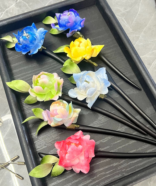 Handmade Ronghua single peony hairpins in blue, yellow, pastel, pink and red mulberry silk velvet flowers on wooden sticks, displayed on black tray