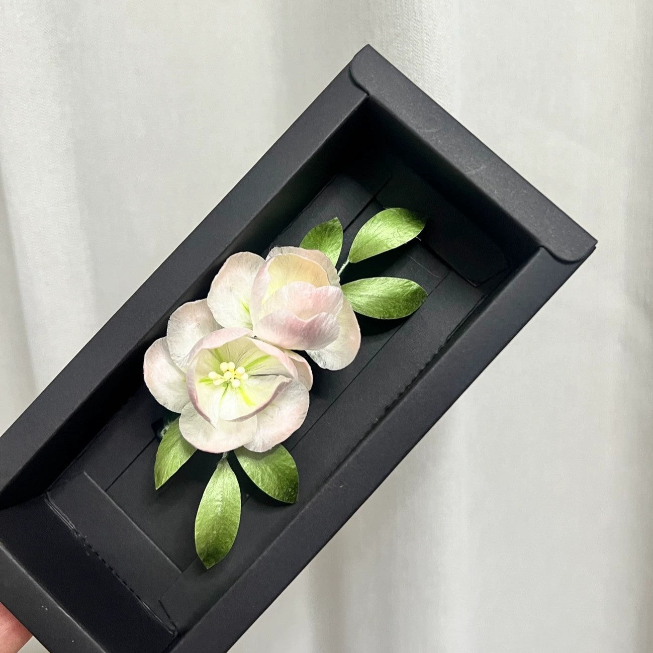 Handmade Ronghua pink camellia brooch in mulberry silk velvet flower with green leaves, presented in black gift box