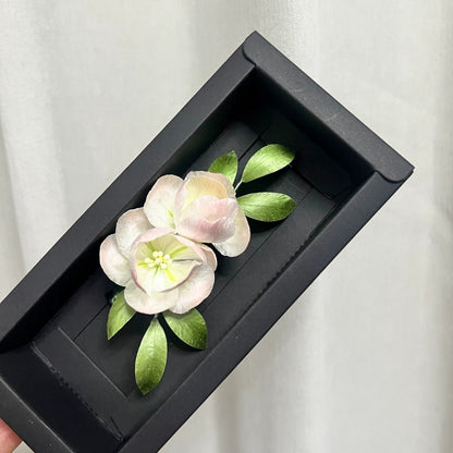 Handmade Ronghua pink camellia brooch in mulberry silk velvet flower with green leaves, presented in black gift box