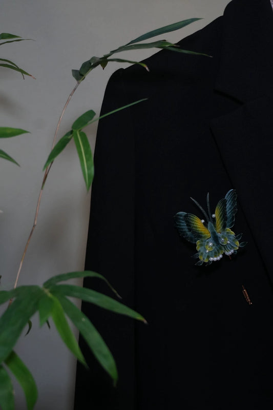 Handmade Ronghua antique-style butterfly brooch in teal and yellow mulberry silk velvet with pearl accents, pinned on black fabric