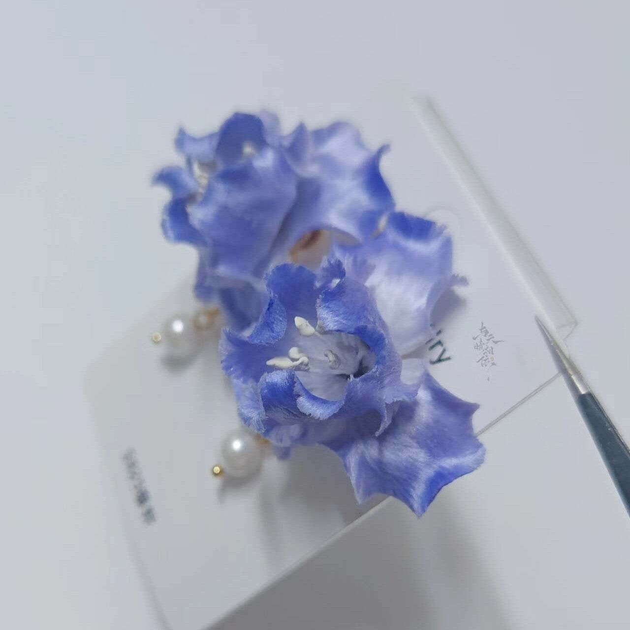 Handmade Ronghua blue iris drop earrings in mulberry silk velvet with pearl and gold chain, displayed on white background