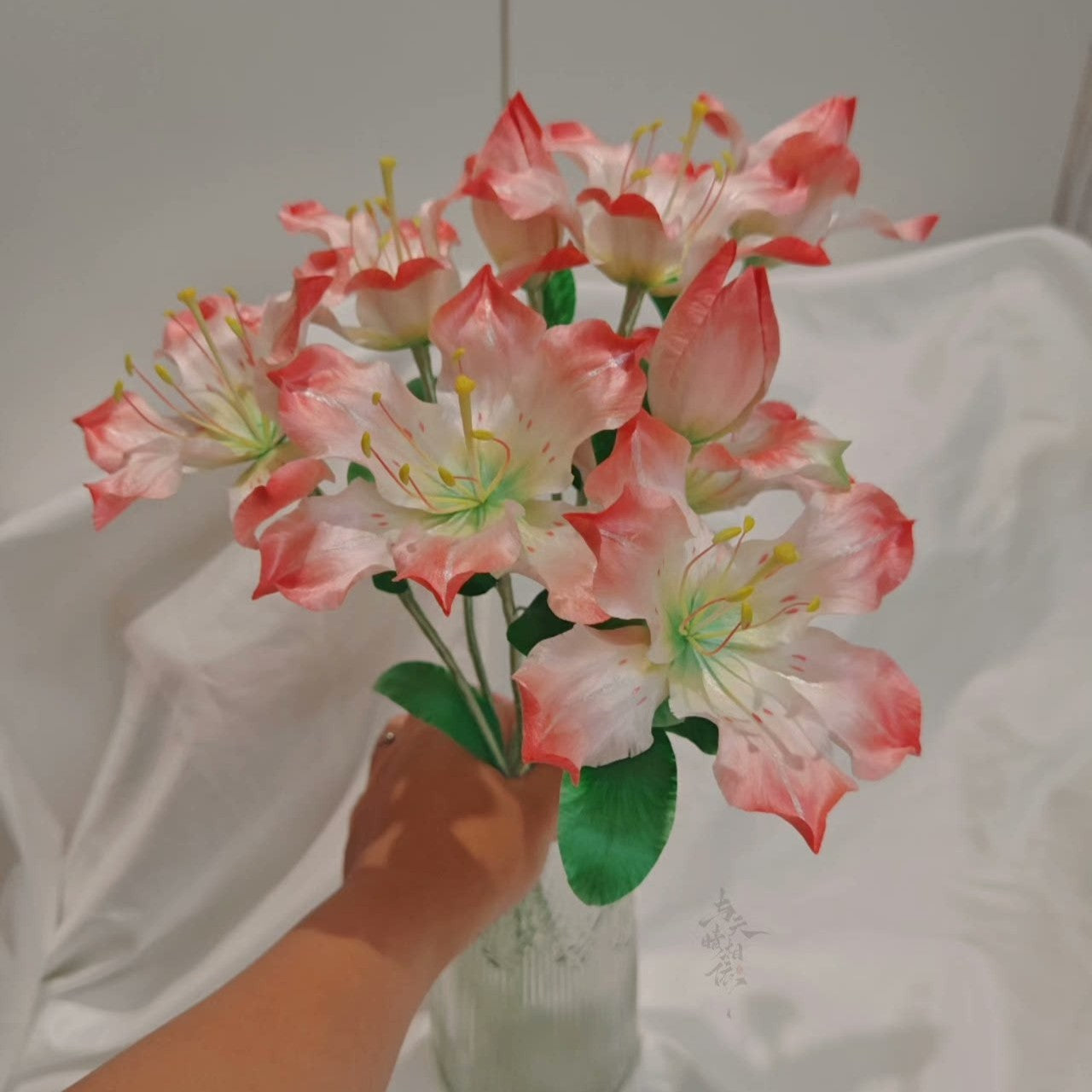 Handmade Ronghua large pink-white lily bouquet stem in mulberry silk velvet with green leaves, held in hand